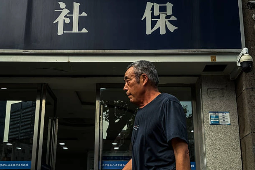 一位白发苍苍的老人走过人力资源和社会保障局的办公室。 (Photo by Cheng Xin/Getty Images)