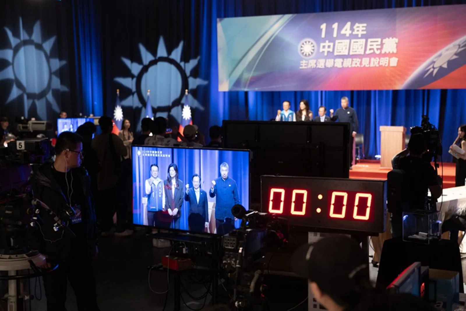 國民黨黨主席選舉電視政見說明會10月5日下午於TBVS電視大樓舉行，國民黨主席候選人於直播開始前進行合影，棚內工作人員進行直播準備作業。（中央社）