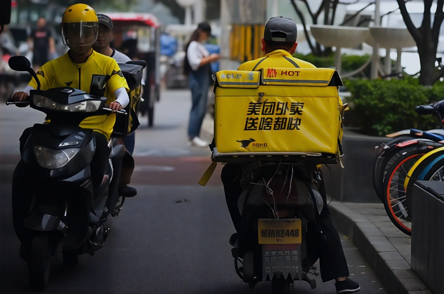 两名美团外卖员骑着摩托车在北京街头送餐。 (Photo by WANG ZHAO / AFP) (Photo credit should read WANG ZHAO/AFP via Getty Images)