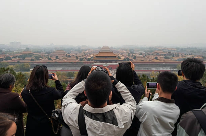 示意图，图为游客在北京景山公园拍摄故宫全景。(Photo by Cheng Xin/Getty Images)