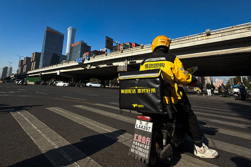 示意圖：一名美團外賣騎手在北京中央商務區附近的一個十字路口等候。(Photo by Cheng Xin/Getty Images)