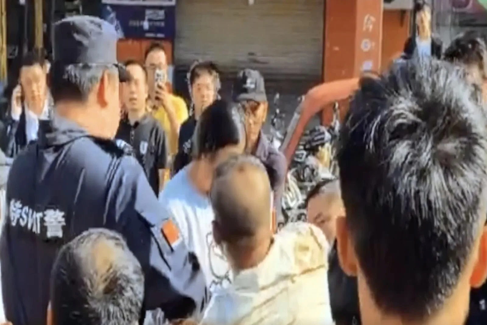湖北漢川漢正服裝城的博朗圖服飾已數月未發工資，累計拖欠金額高達數百萬元。圖為稍早前討薪工人與警方爆發衝突。（視頻擷圖）
