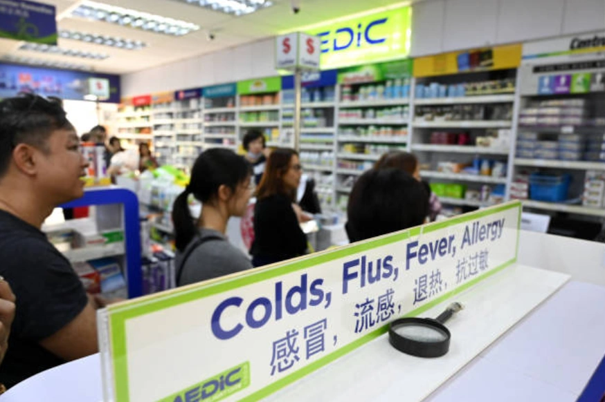示意圖：人們在一家藥店外排隊。 (Photo by Roslan RAHMAN / AFP) (Photo by ROSLAN RAHMAN/AFP via Getty Images)