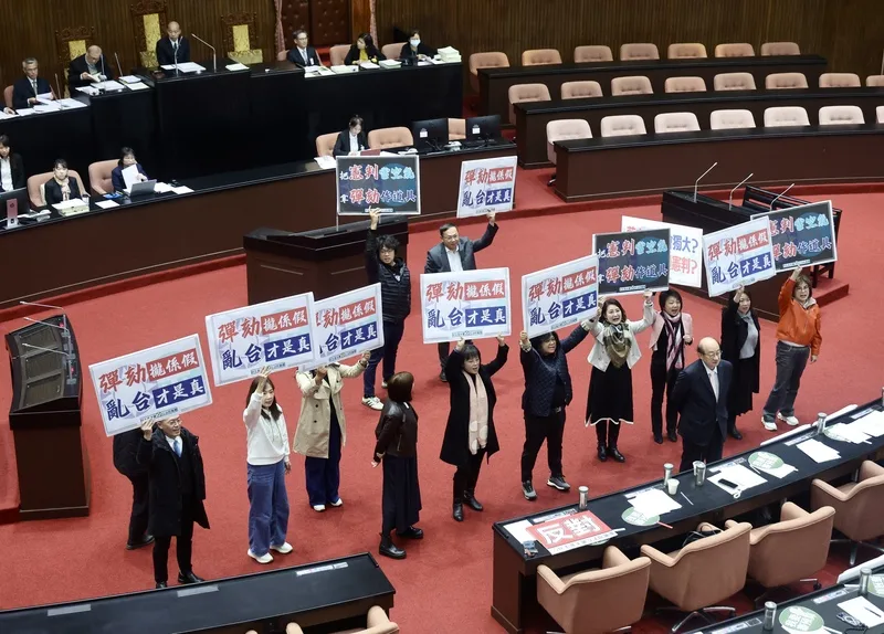 台灣立法院會12月26日通過對總統賴清德啟動彈劾案程序，民進黨團在議場舉牌抗議。（中央社）