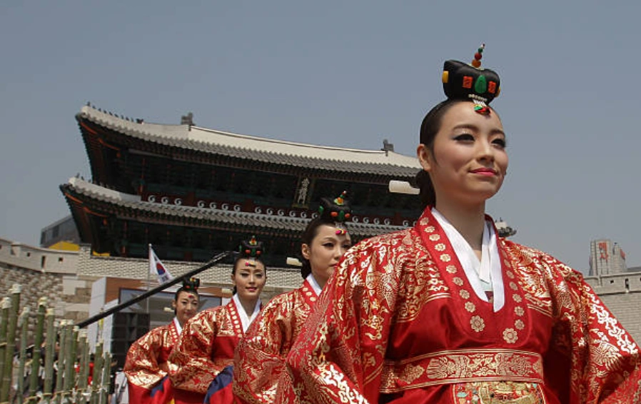 资料图：身着传统服饰的韩国民众在首尔崇礼门修复竣工仪式上表演。(Photo by Chung Sung-Jun/Getty Images)