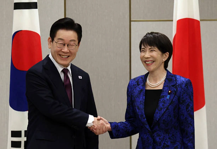 2026年1月13日：日本首相高市早苗（右）在日韩峰会前夕与韩国总统李在明握手。(Photo by Issei Kato - Pool/Getty Images)