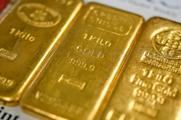 三塊各重 1 公斤的金條整齊擺放在伯明翰珠寶區一家黃金經銷商的櫃檯上。（Christopher Furlong/Getty Images）