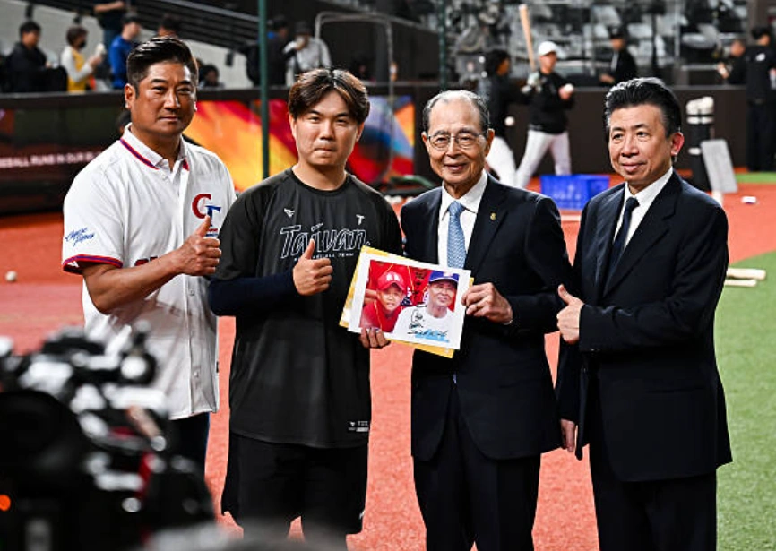 东京巨蛋自1988年3月开幕至今，38年来，从来没有在任何棒球比赛中涌入这么多台湾观众。 图为2026年2月26日：（从左至右）中华台北棒球协会会长顾国荣、中华台北队90号球员江坤宇、福冈软银鹰队主席王贞治、王贞治的医生郭宗明在台北巨蛋举行的软银鹰队与中华台北队的练习赛前合影。 (Photo by Gene Wang - Capture At Media/Getty Images)