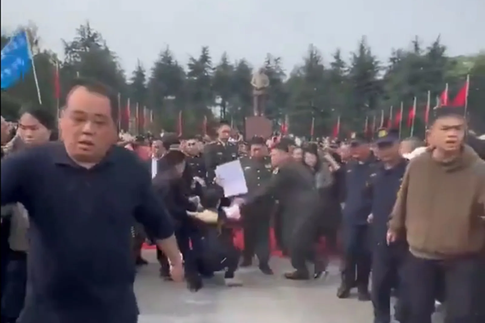 前中共黨魁毛澤東之孫毛新宇日前回湖南祭祖時，突有一名女子手持多張紙衝到他面前，疑要向他訴冤，但被毛新宇身旁的隨從拖走。（視頻擷圖）