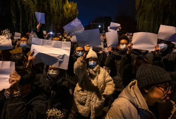中國年輕人2022年11月27日在北京參加「白紙運動」，抗議中共對疫情的清零政策。（Kevin Frayer/Getty Images）